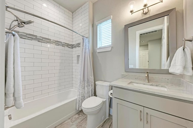 full bathroom featuring shower / bath combo, vanity, and toilet