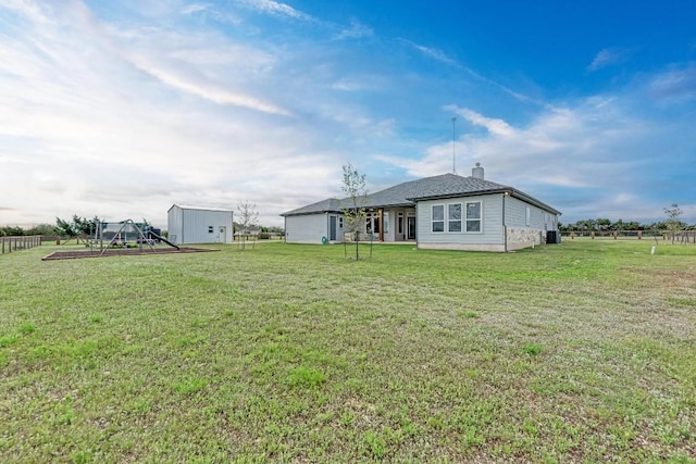 back of house featuring a yard and a storage unit