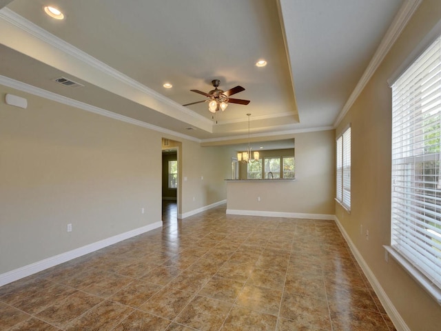 empty room with ceiling fan with notable chandelier, a raised ceiling, and ornamental molding