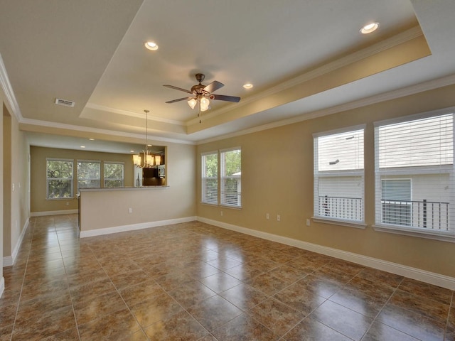 tiled spare room featuring a tray ceiling, crown molding, and a healthy amount of sunlight