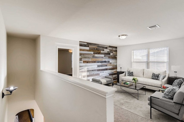 carpeted living room with wooden walls