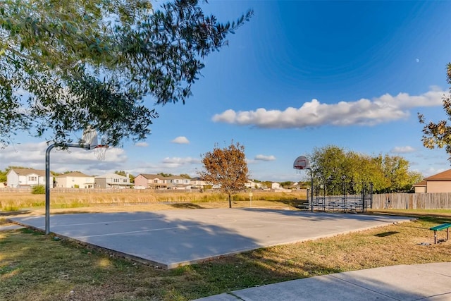 view of sport court with a lawn