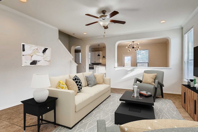 tiled living room featuring plenty of natural light, crown molding, and ceiling fan with notable chandelier