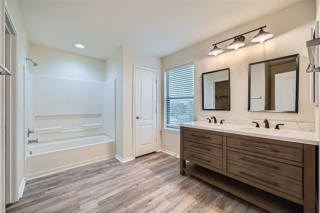 bathroom featuring vanity, hardwood / wood-style flooring, and bathing tub / shower combination