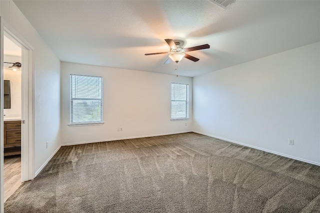 carpeted spare room with ceiling fan