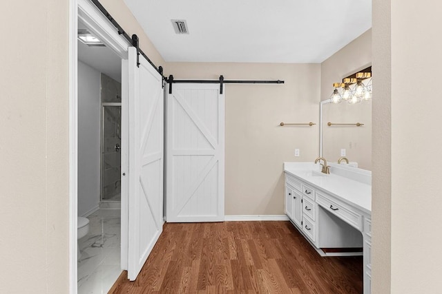 bathroom with hardwood / wood-style flooring, vanity, and toilet