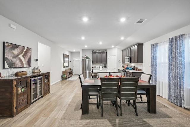 dining area featuring light wood-type flooring and wine cooler