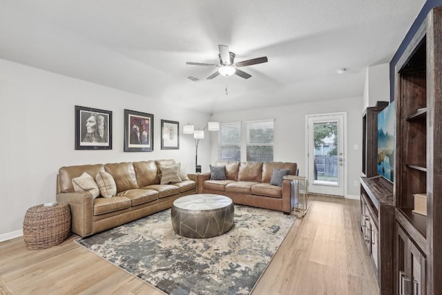 living room with light hardwood / wood-style flooring and ceiling fan