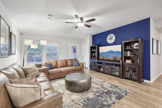 living room with light hardwood / wood-style floors, vaulted ceiling, and ceiling fan