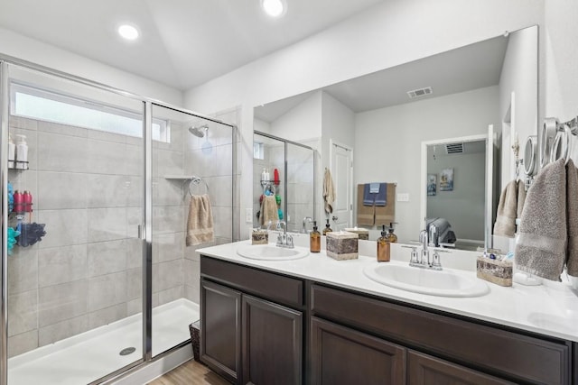 bathroom with hardwood / wood-style floors, vanity, and a shower with door