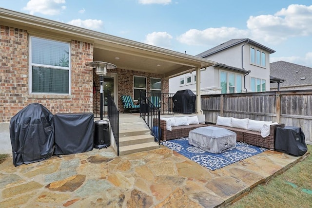 exterior space featuring a patio, an outdoor hangout area, brick siding, and a fenced backyard
