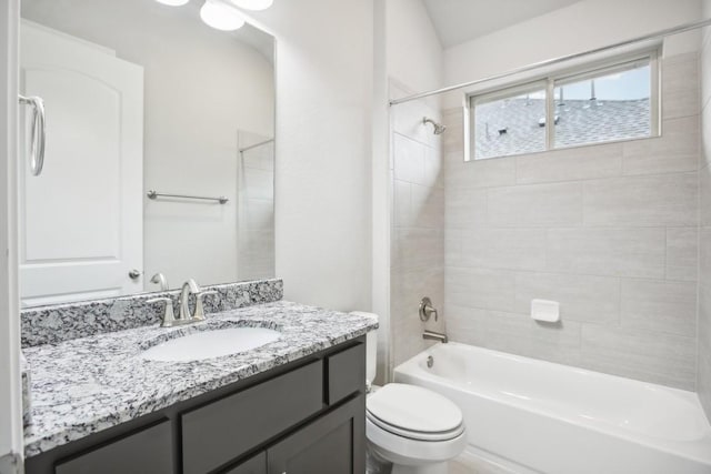 full bathroom with vanity, tiled shower / bath combo, and toilet