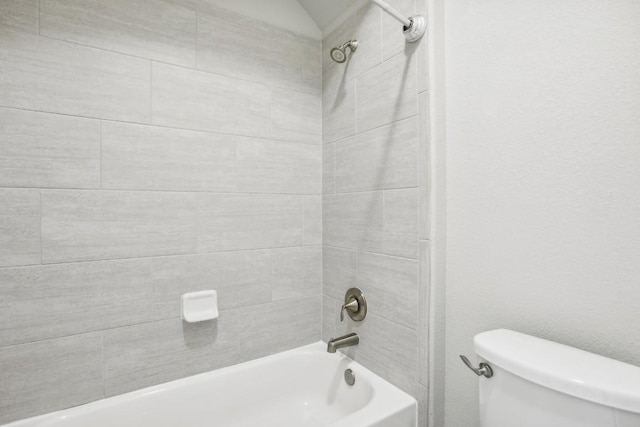 bathroom with toilet and tiled shower / bath