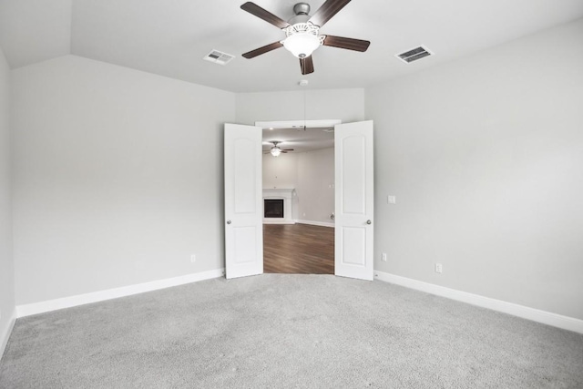 unfurnished room featuring carpet floors, vaulted ceiling, and ceiling fan