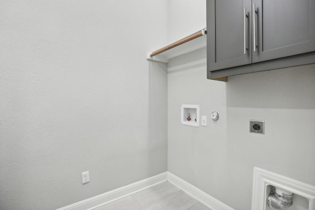 washroom featuring hookup for an electric dryer, washer hookup, gas dryer hookup, and cabinets