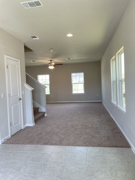 carpeted spare room with ceiling fan