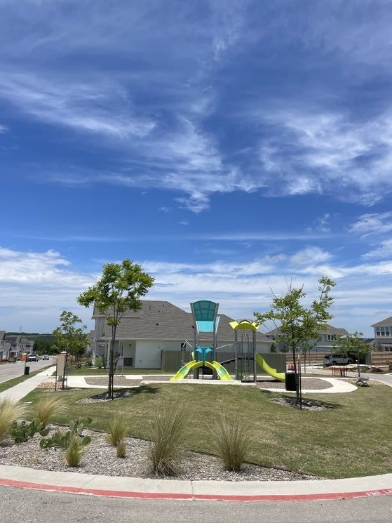 view of home's community featuring a lawn and a playground