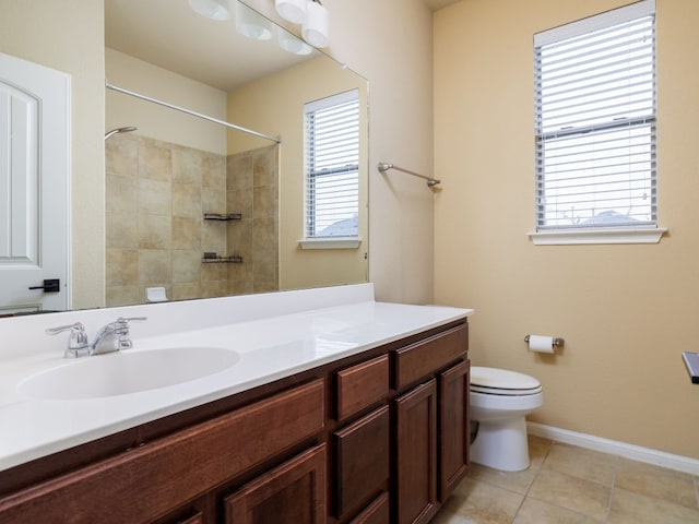 bathroom featuring toilet, plenty of natural light, vanity, and tile patterned floors