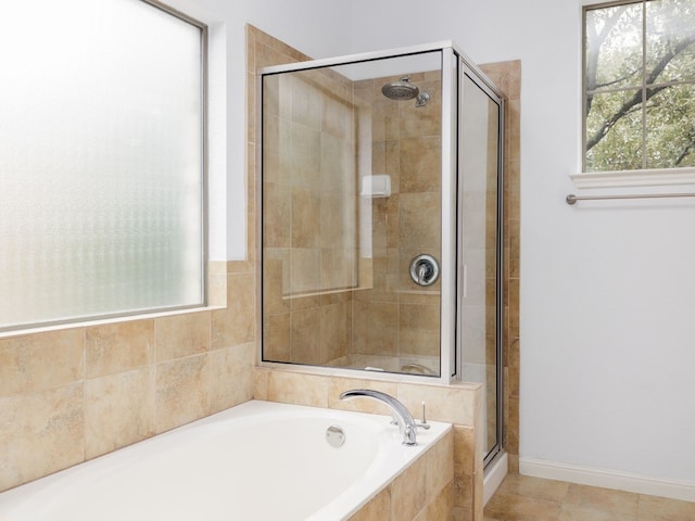 bathroom with a garden tub, a shower stall, baseboards, and tile patterned floors