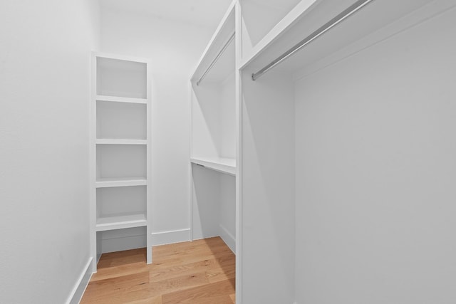 spacious closet with light hardwood / wood-style flooring