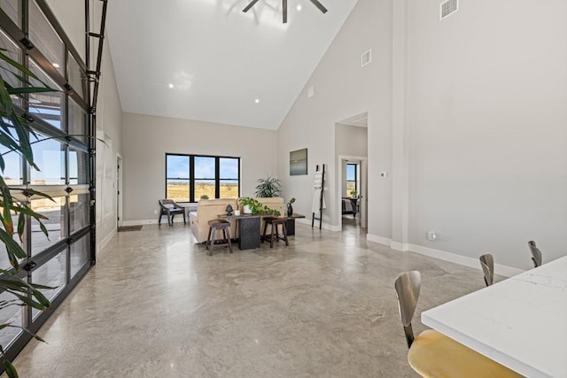 interior space with ceiling fan and a towering ceiling