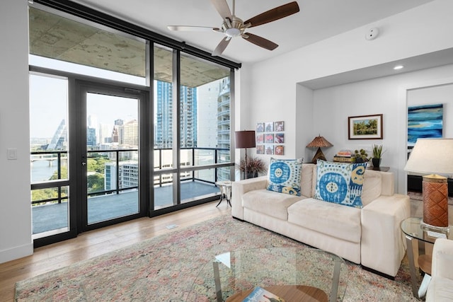 70 Rainey St Unit 1306, Austin, TX 78701 - living room with a wall of windows, a ceiling fan, a city view, and wood finished floors