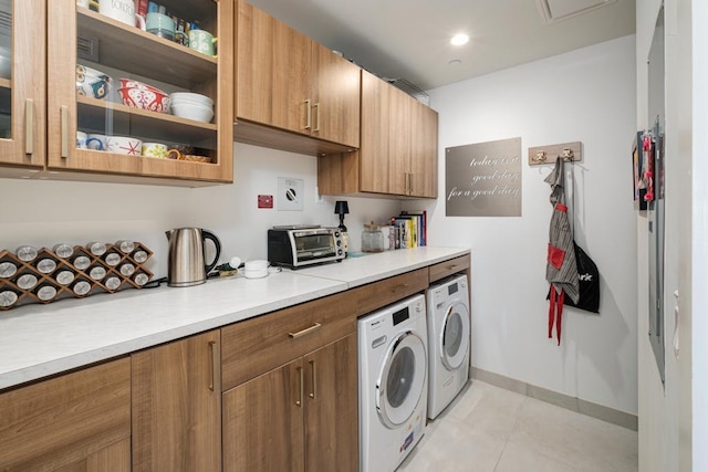 70 Rainey St Unit 1306, Austin, TX 78701 - washroom featuring independent washer and dryer, light tile patterned floors, baseboards, and cabinet space