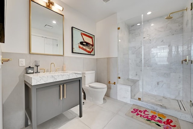 70 Rainey St Unit 1306, Austin, TX 78701 - full bath with toilet, a shower stall, vanity, tile walls, and tile patterned floors
