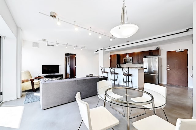 800 Brazos St Unit 705, Austin, TX 78701 - dining space with finished concrete flooring, track lighting, and a barn door