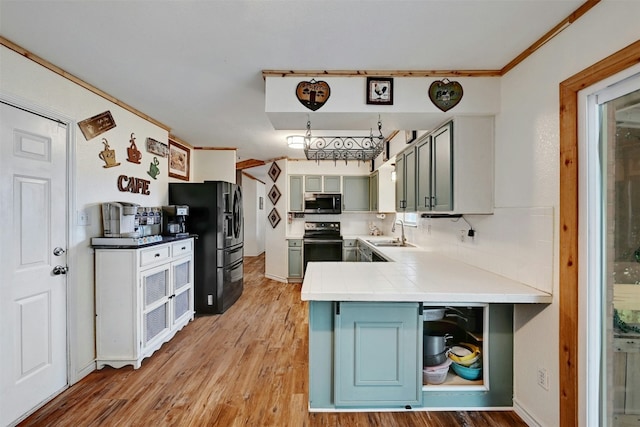 228 Old Firetower Rd, Bastrop, TX 78602 - kitchen with stainless steel microwave, range with electric cooktop, black refrigerator with ice dispenser, light wood finished floors, and crown molding