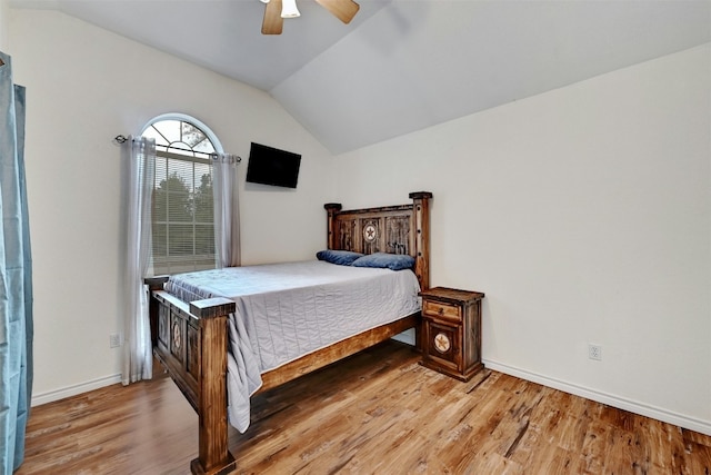 bedroom featuring light wood-type flooring, vaulted ceiling, and ceiling fan