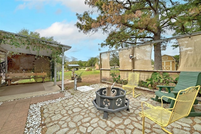 view of patio / terrace with a fire pit and a storage unit