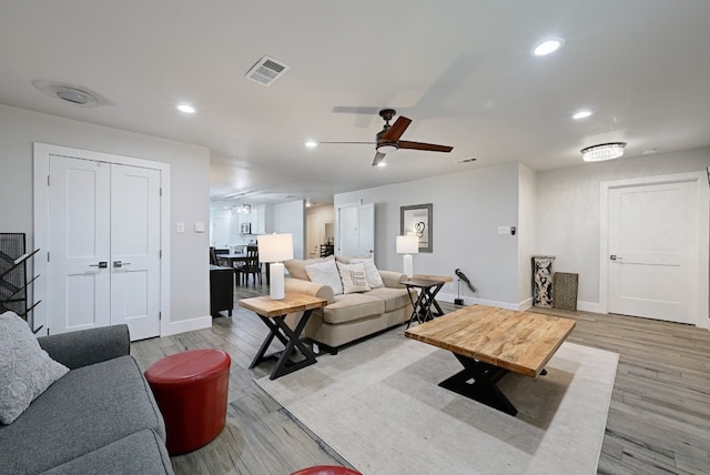 living room with ceiling fan and light wood-type flooring