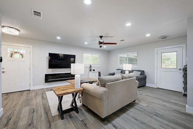 living room featuring light hardwood / wood-style flooring and ceiling fan