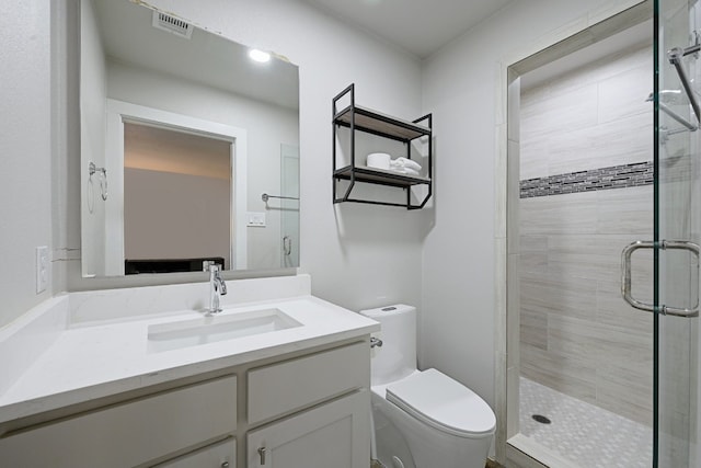 bathroom with vanity, a shower with shower door, and toilet