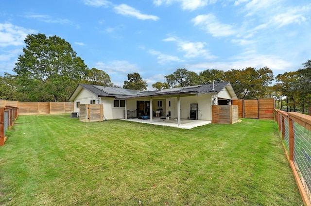 back of house with solar panels, a yard, a patio, and cooling unit