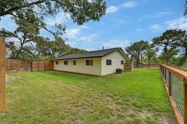 back of house with central AC and a lawn