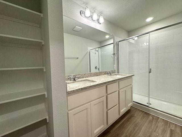 bathroom with vanity, an enclosed shower, and wood-type flooring