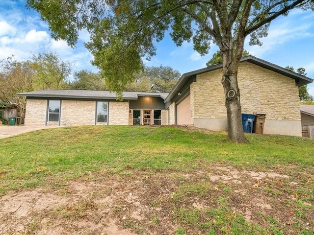 rear view of house with a lawn and a garage