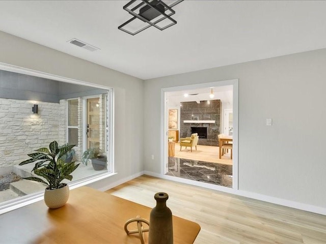 workout room featuring a tile fireplace and hardwood / wood-style flooring