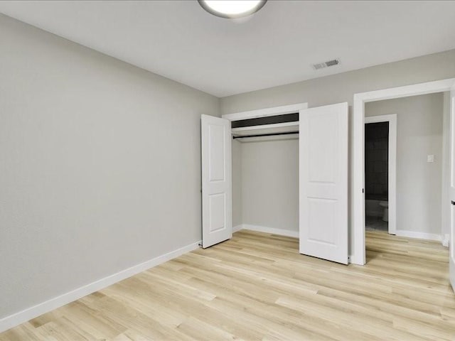 unfurnished bedroom featuring light hardwood / wood-style floors and a closet