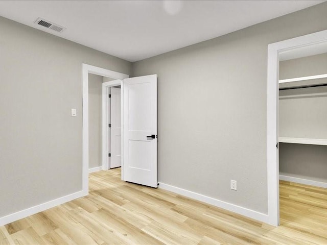 unfurnished bedroom featuring a closet and light wood-type flooring