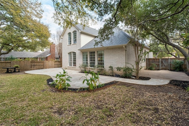 rear view of house with a yard and a patio area