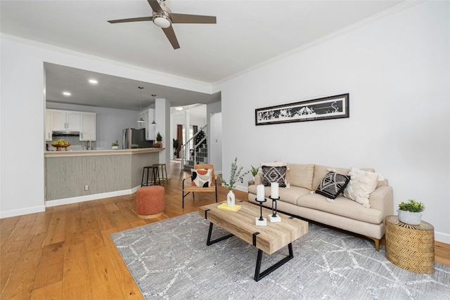 living room featuring ceiling fan, wood-type flooring, and ornamental molding