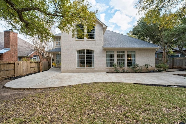 rear view of property featuring a patio area and a yard