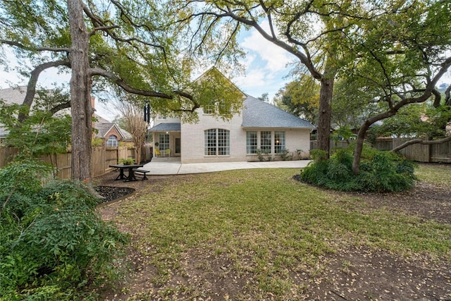 back of house with a lawn and a patio