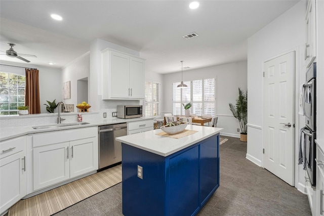 kitchen with a wealth of natural light, a center island, sink, and appliances with stainless steel finishes