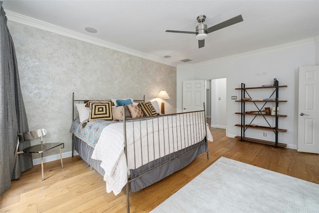 bedroom featuring hardwood / wood-style flooring, ceiling fan, and crown molding