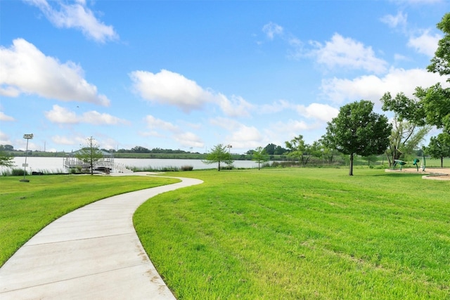 surrounding community featuring a water view and a lawn