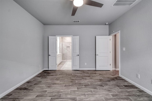 unfurnished bedroom featuring ensuite bath and ceiling fan